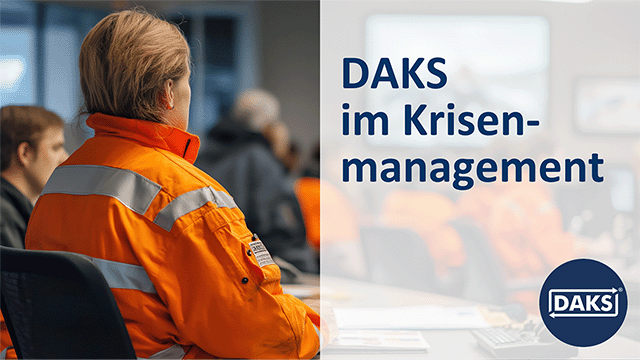 Text panel on the right &lsquo;DAKS in crisis management&rsquo; in front of a group of people in orange overalls in a briefing situation