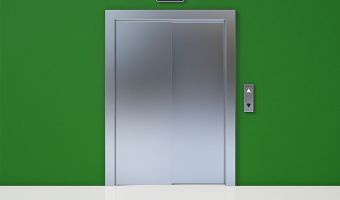 Closed elevator door in a green-painted wall