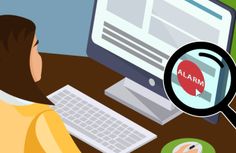 Employee sits in front of screen with small alarm button